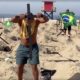 Homem colocando cruz na praia de Copacabana