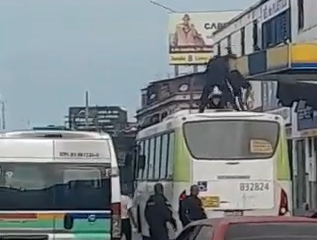 Policiais tentam imobilizar homem em cima de ônibus [Foto: Reprodução]