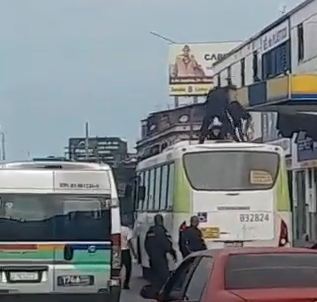 Policiais tentam imobilizar homem em cima de ônibus [Foto: Reprodução]