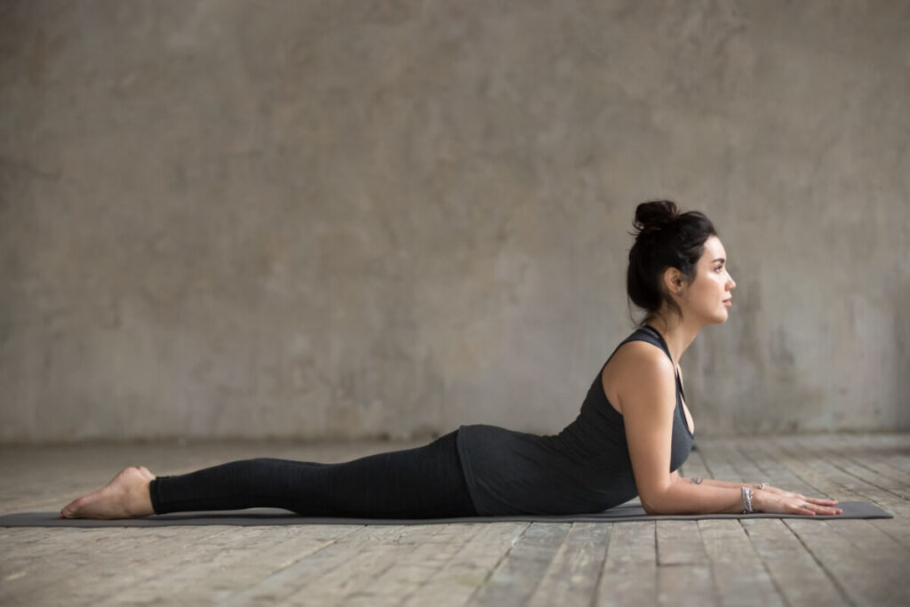 Mulher fazendo a postura de cobra da yoga