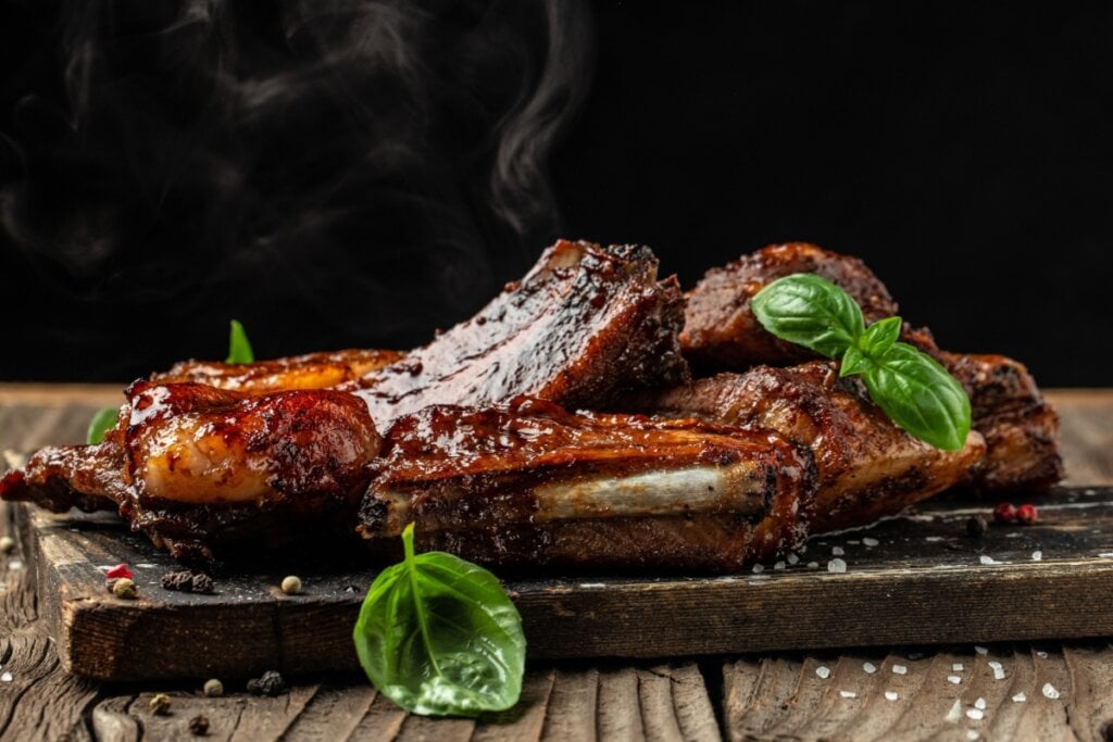 Pedaços de costela de porco grelhados servidos em mesa de madeira