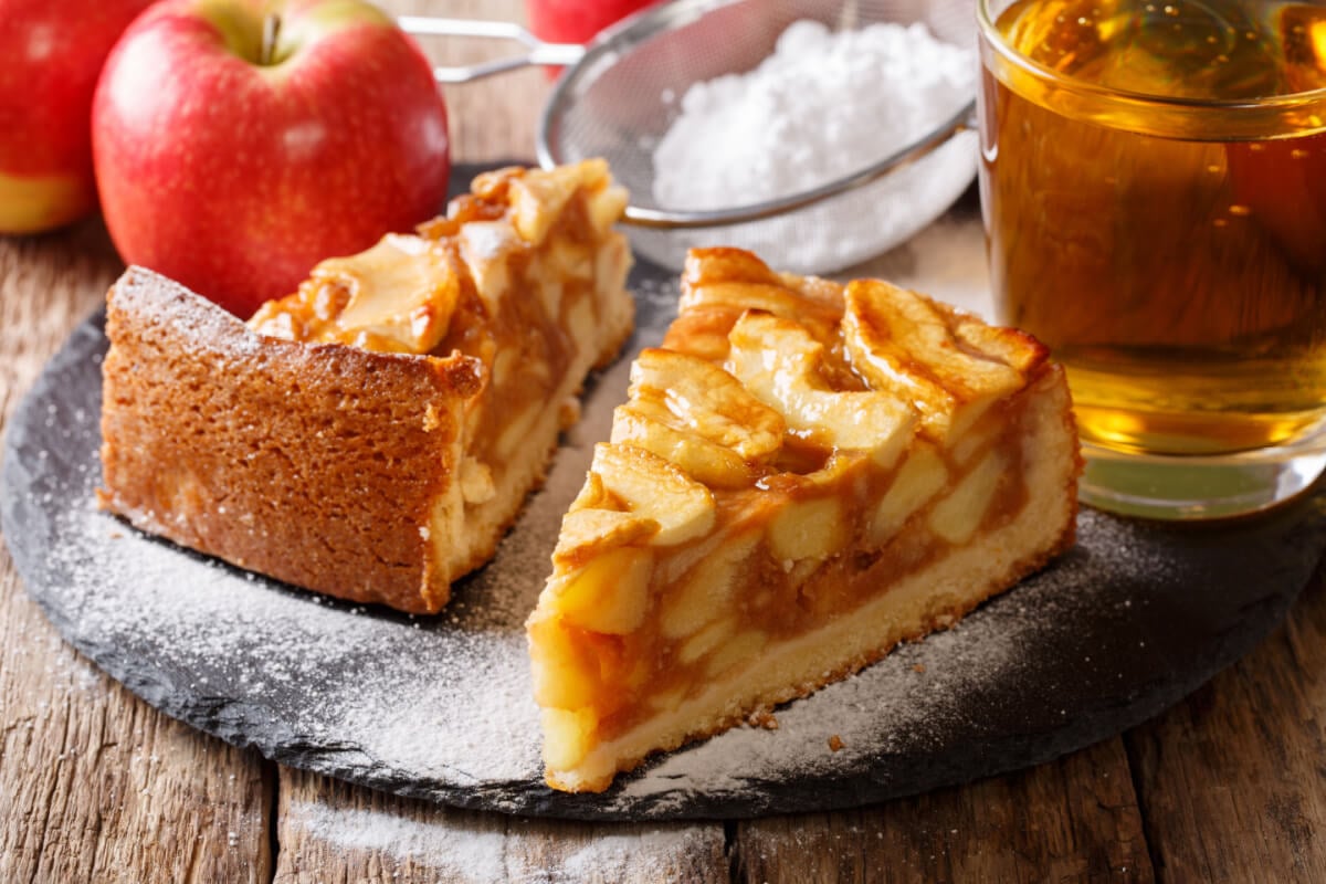 Duas fatias de torta de maçã em superfície com açúcar de confeiteiro