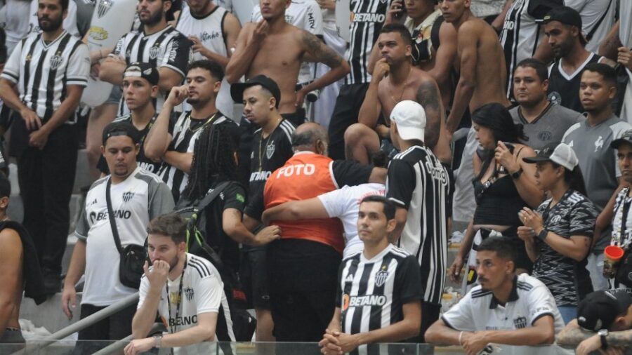 Fotógrafo é carregado para atendimento após ser atingido por bomba na beira do gramado da Arena MRV