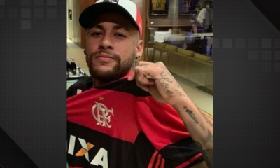 Neymar, usando um boné e segurando a camisa do Flamengo