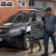 Homem preso por feminicídio é levado à delegacia por policiais.