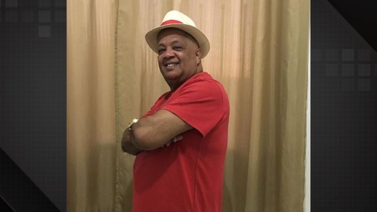 intérprete Luizinho Andanças em uma blusa vermelha, sorrindo para a câmera