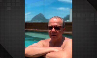 Imagem de Sérgio Cabral de óculos escuros, com os braços apoiados na borda de uma piscina. Ao fundo, é possível ver o Pão de Açúcar e o céu azul no Rio de Janeiro