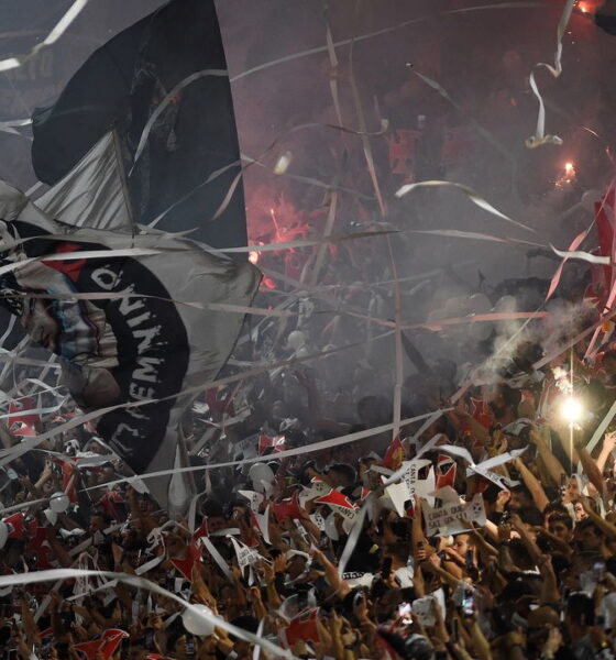 Torcida do Vasco em festa em São Januário, com bandeiras, papel picado e sinalizadores, em um ambiente de celebração