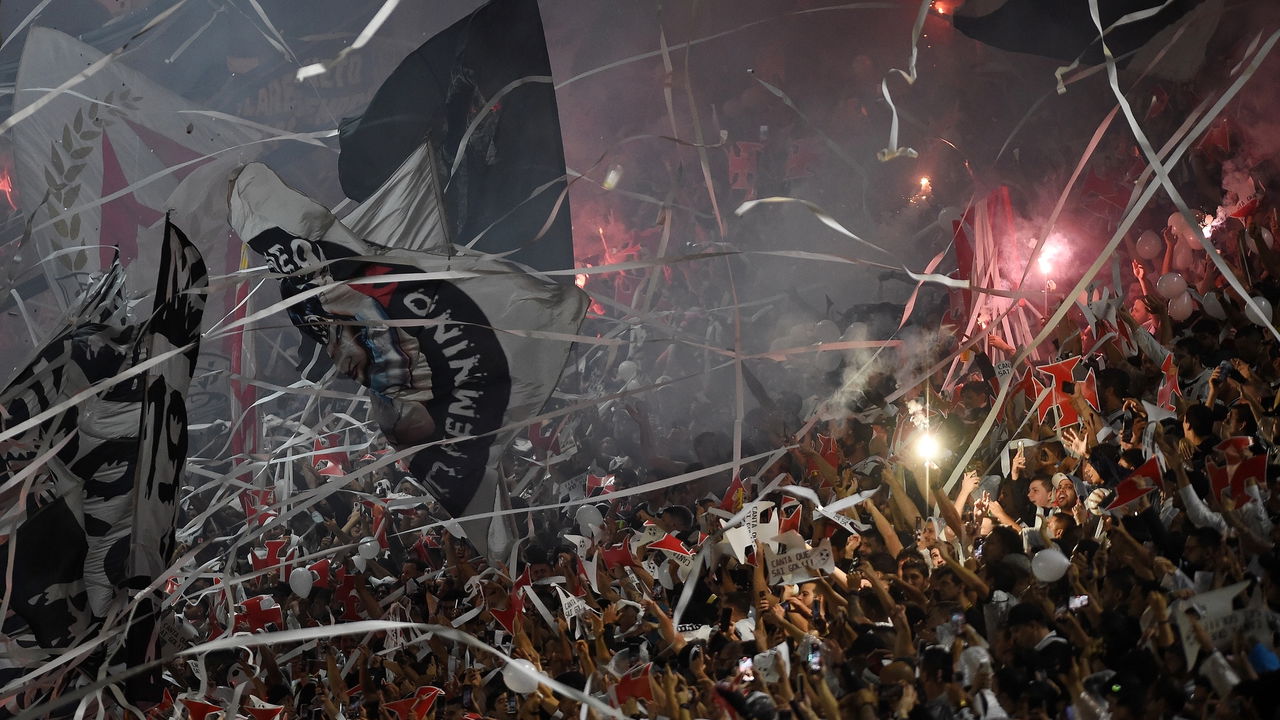 Torcida do Vasco em festa em São Januário, com bandeiras, papel picado e sinalizadores, em um ambiente de celebração