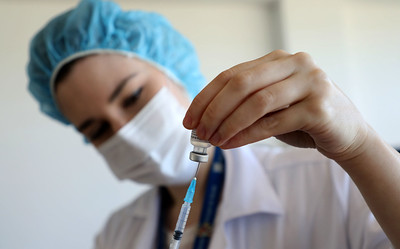 Imagem de uma enfermeira segurando uma seringa