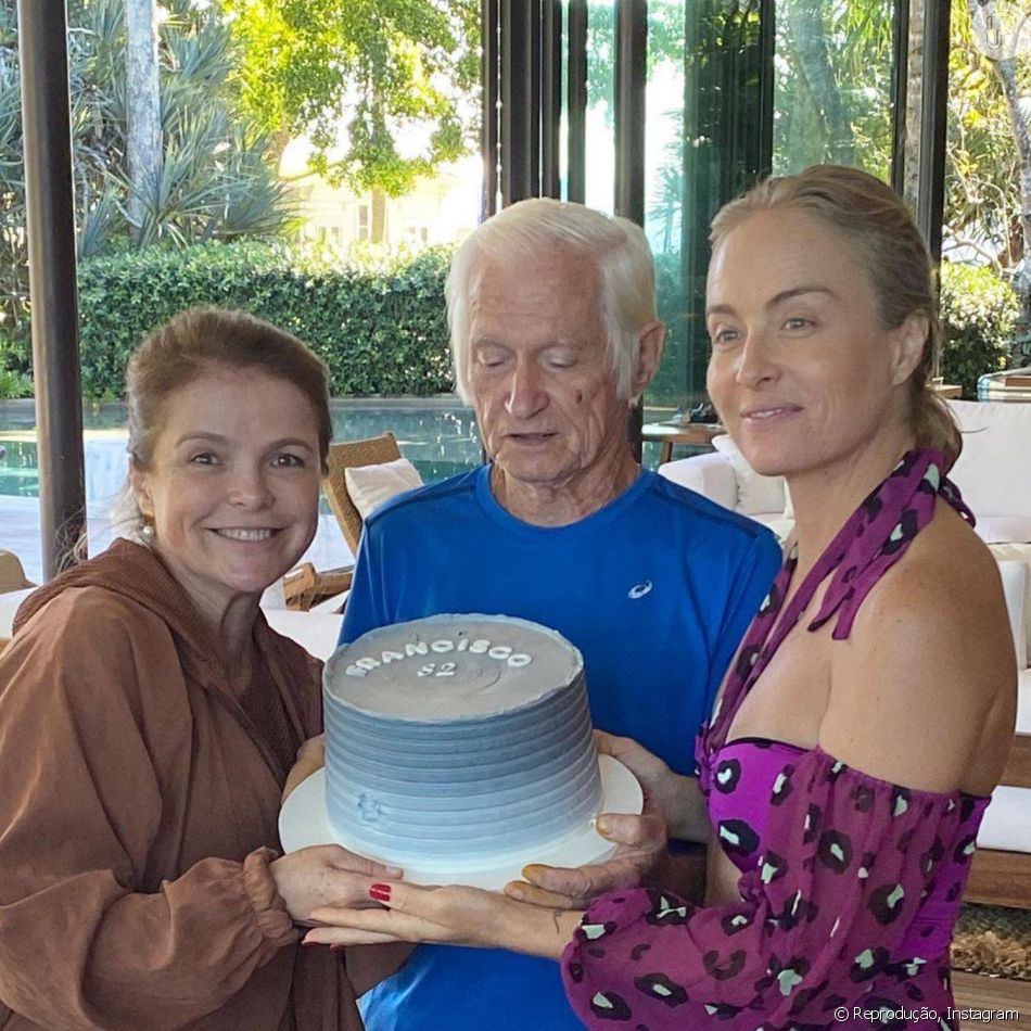 Angélica e a irmã, Márcia, segurando o bolo de aniversário do pai Francisco