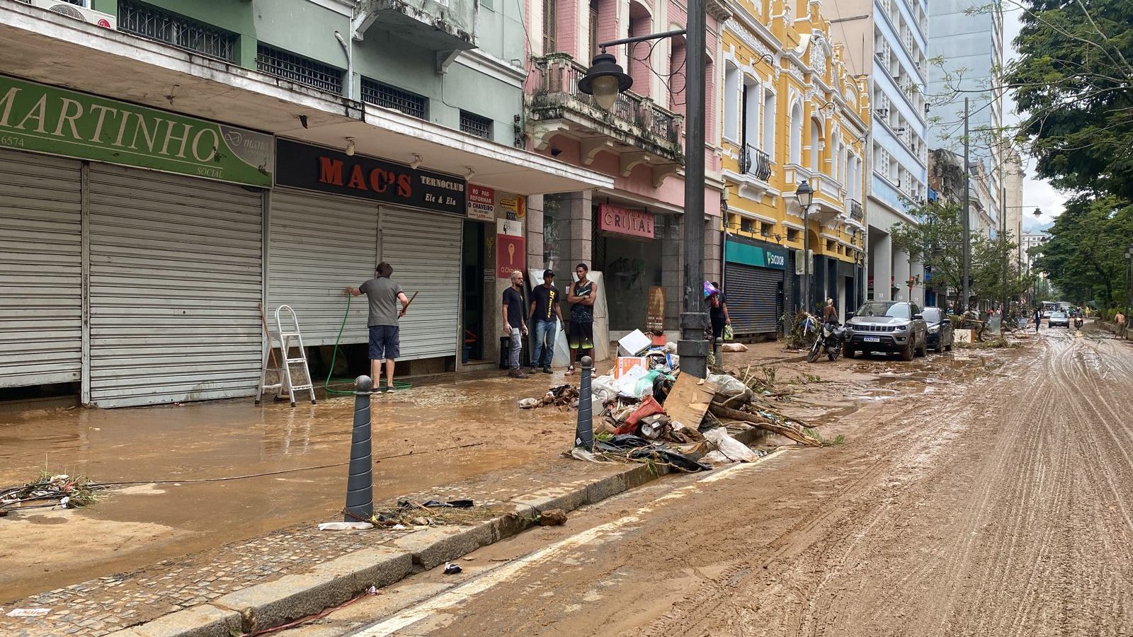 Comerciantes limpam rua em Petrópolis após temporal