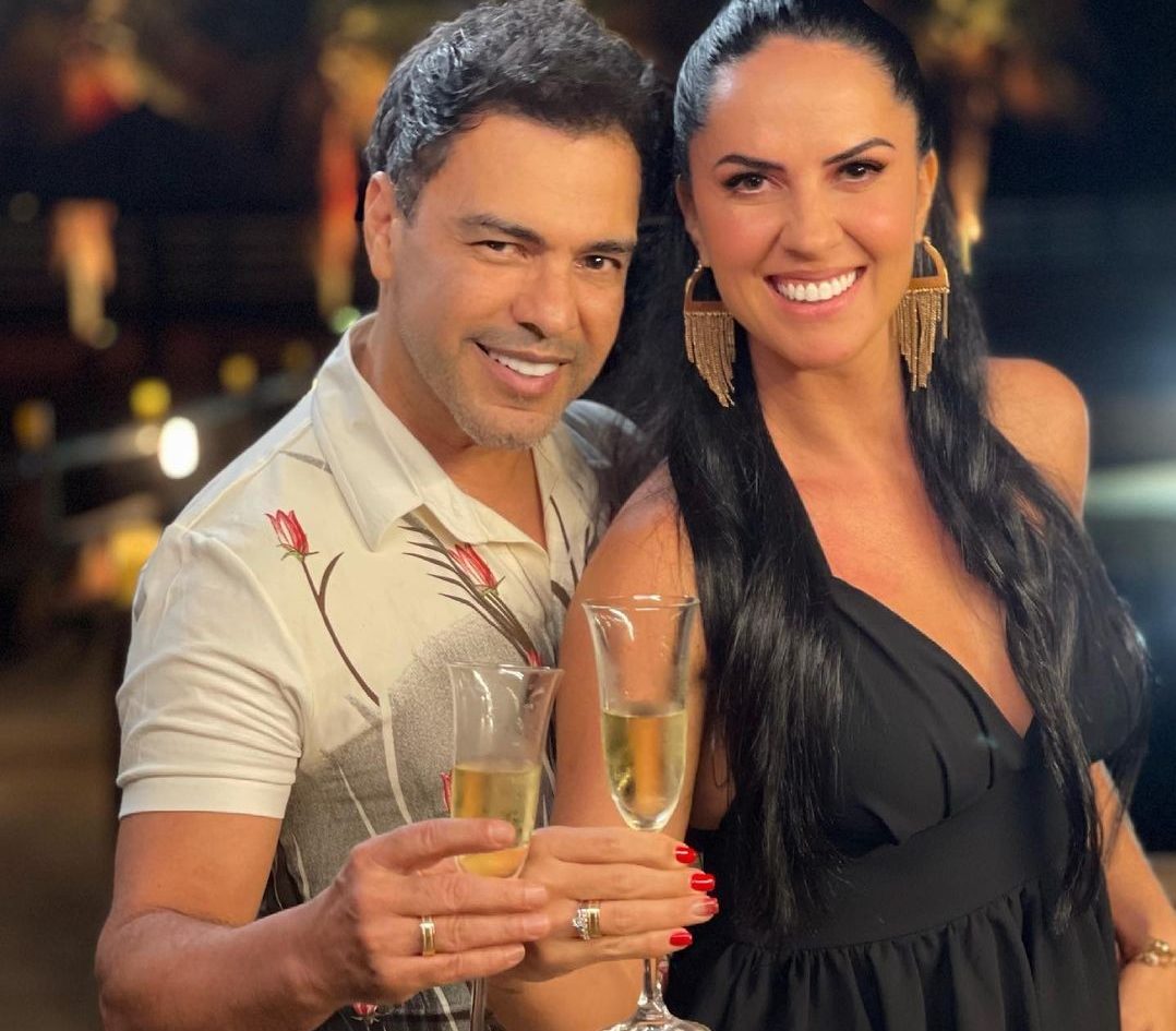 Zezé di Camargo e Graciele Lacerda mostrando aliança de noivado e segurança uma taça de champagne