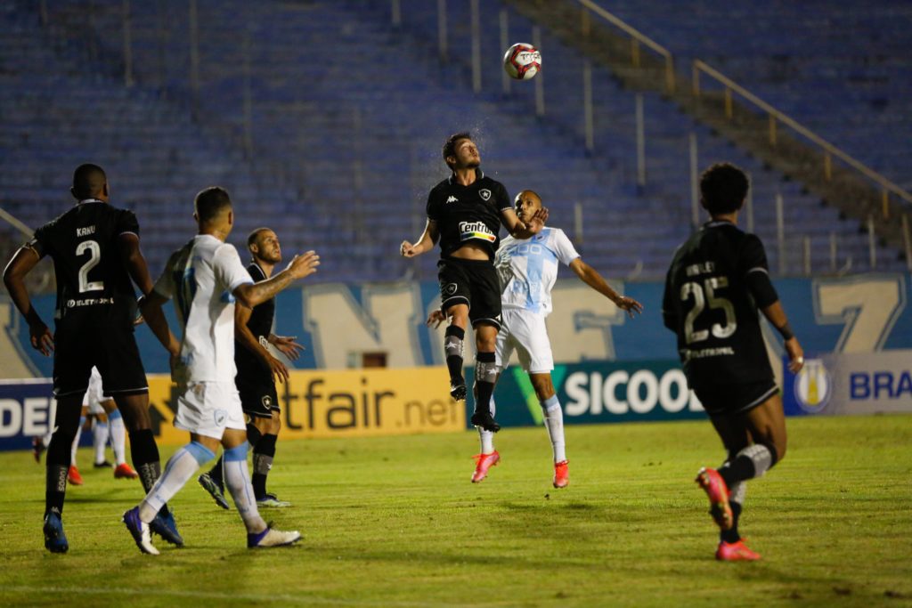 Volante do Botafogo Luis Oyama disputa uma bola de cabeça com adversário 