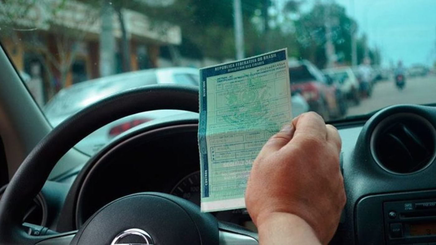 motorista segurando documento do IPVA