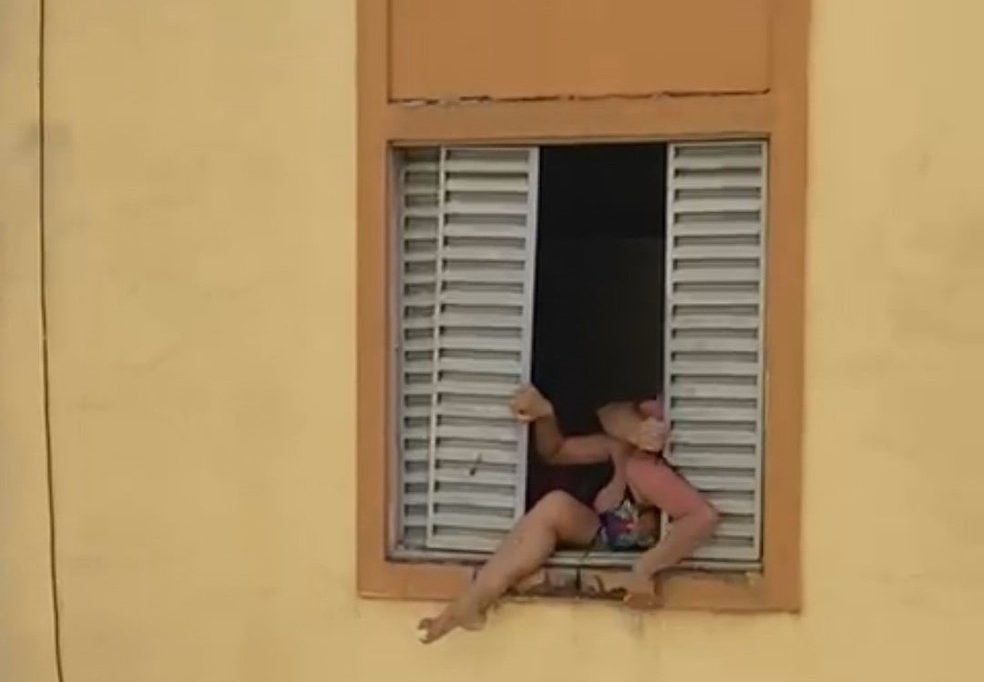 Maria José foi filmada tentando pular a janela do segundo andar durante a briga — Foto: Reprodução/rede social